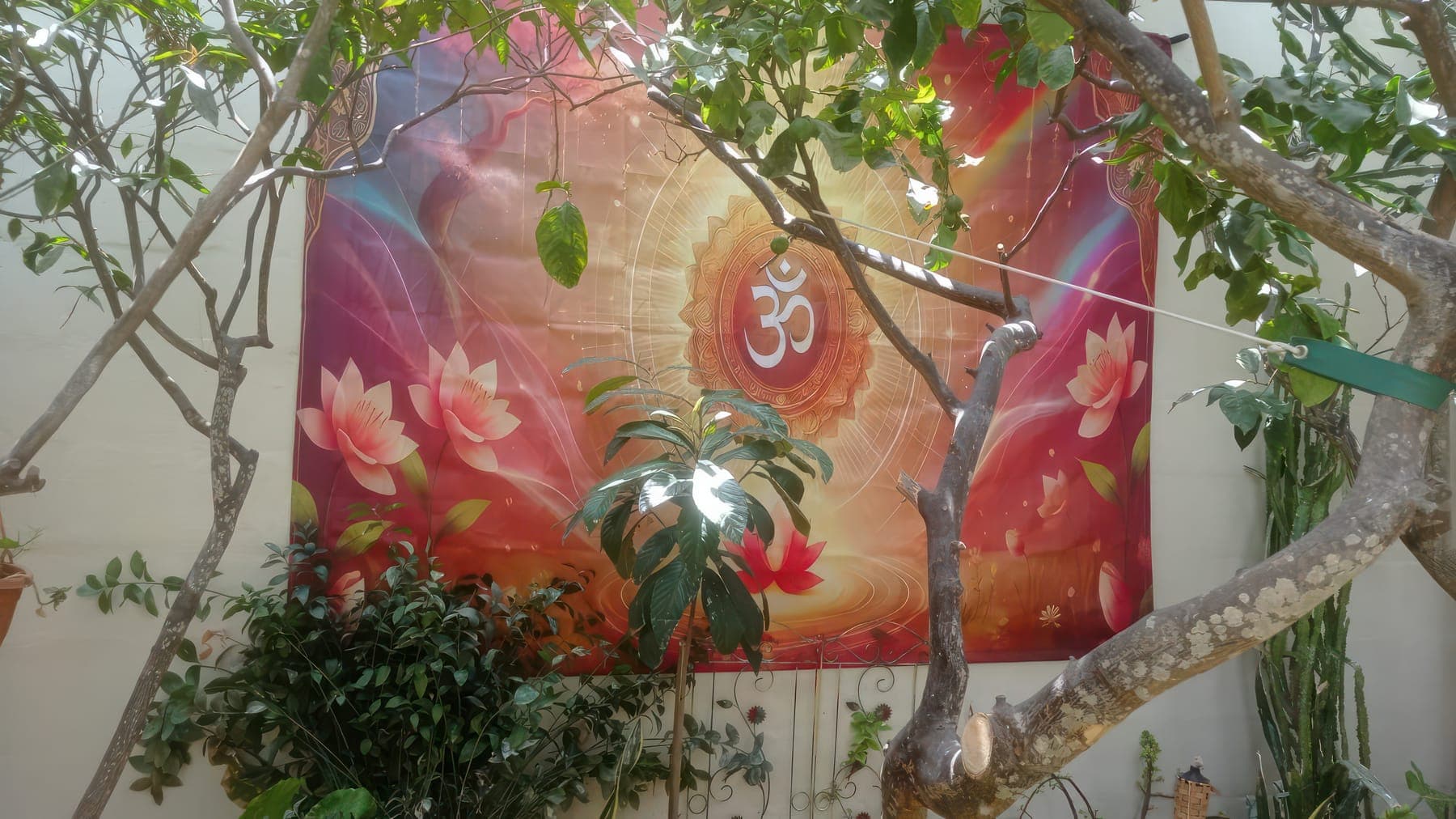 An Om tapestry among the trees of the Zen garden