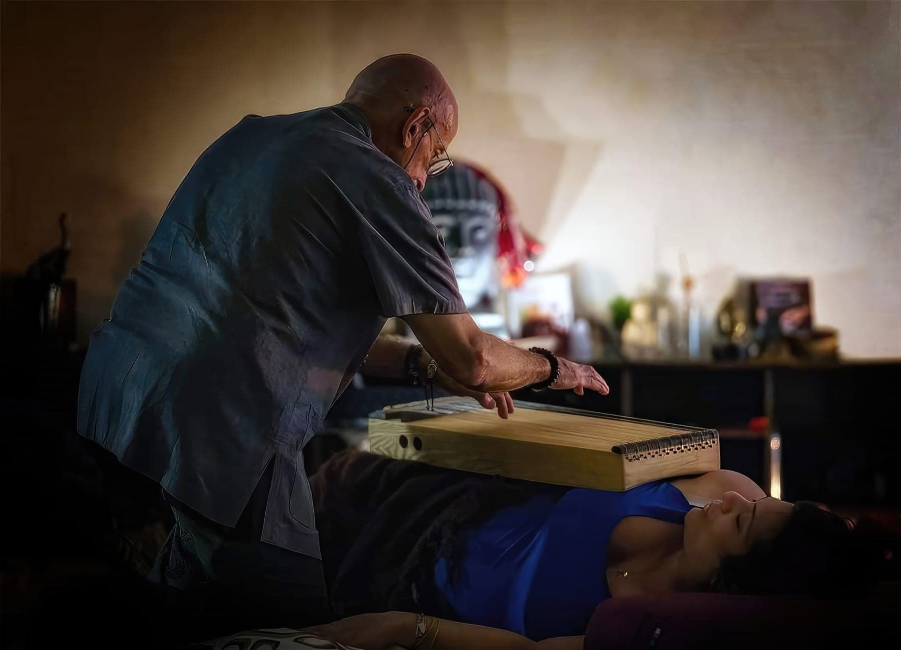 George plays a monochord resting on a guest's body